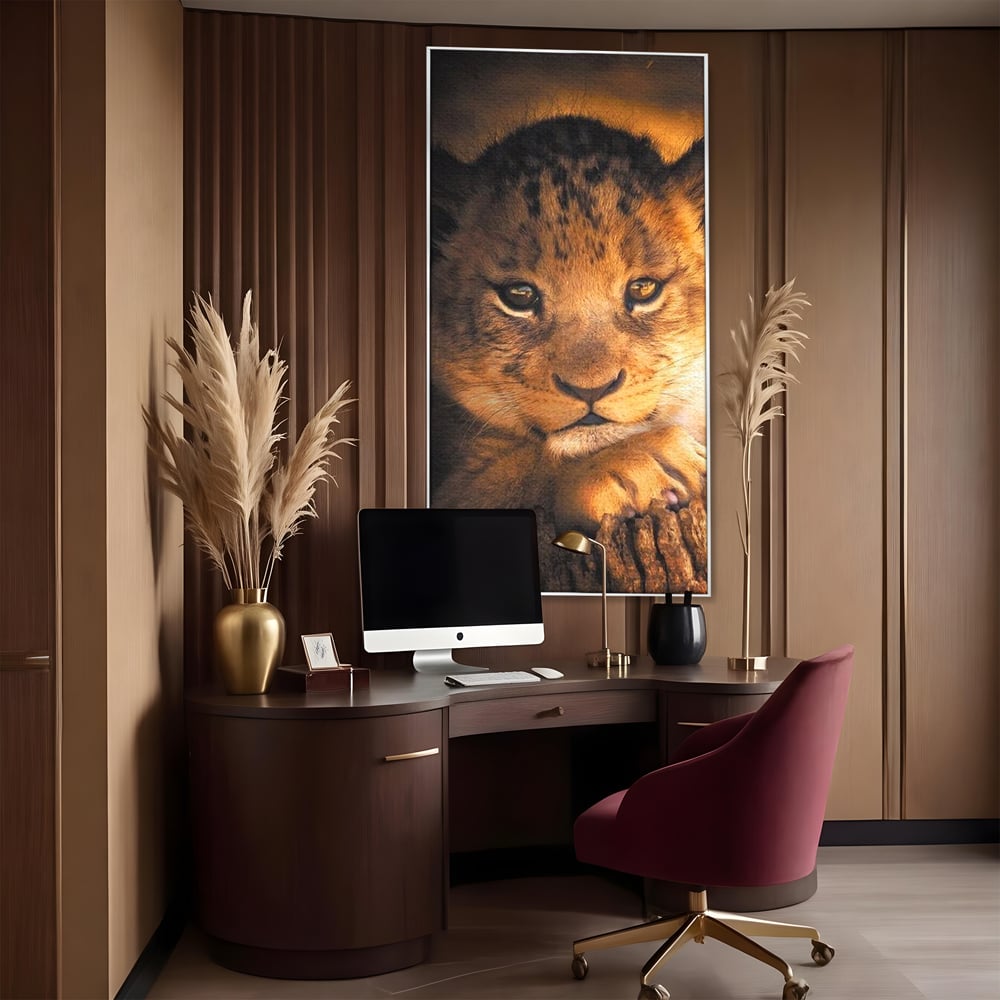 Tablou canvas cu tablou canvas cu portret de pui de leu, in rama de aluminiu argintiu, pe perete intr-un birou